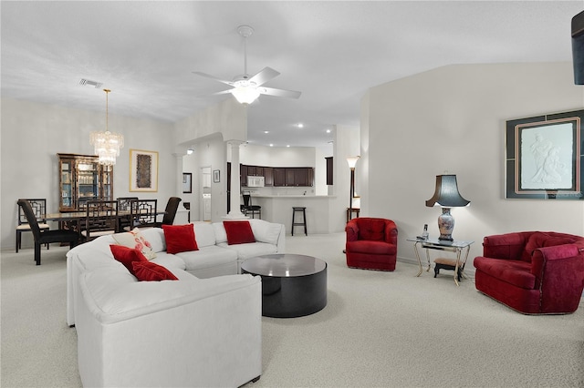 living area with light carpet, ornate columns, a chandelier, ceiling fan, and baseboards