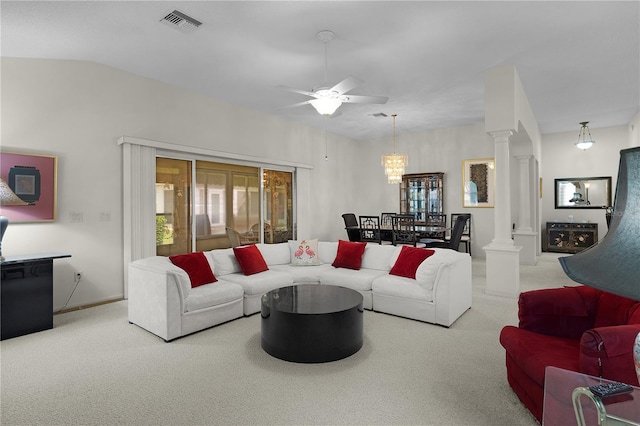 carpeted living room with decorative columns, ceiling fan, and a chandelier