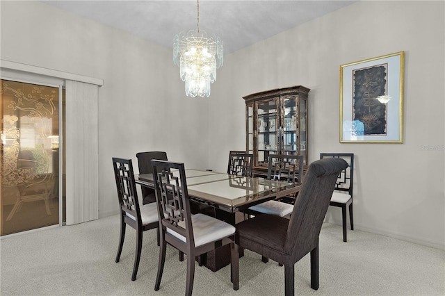 dining room with a chandelier, carpet floors, and baseboards