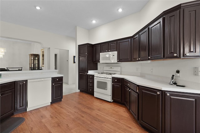 kitchen featuring white appliances, dark brown cabinets, light countertops, light wood finished floors, and recessed lighting