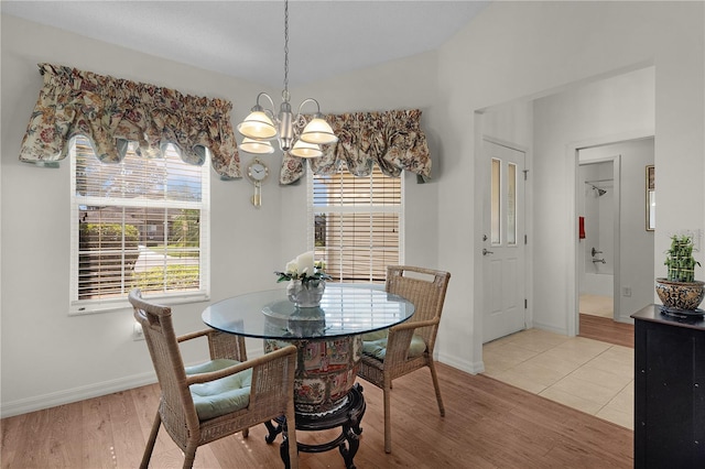 dining room featuring a chandelier, light wood-style floors, and baseboards