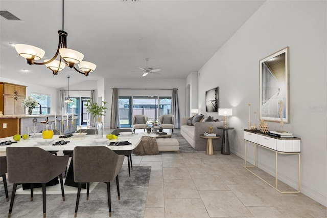 dining area with light tile patterned flooring and ceiling fan with notable chandelier