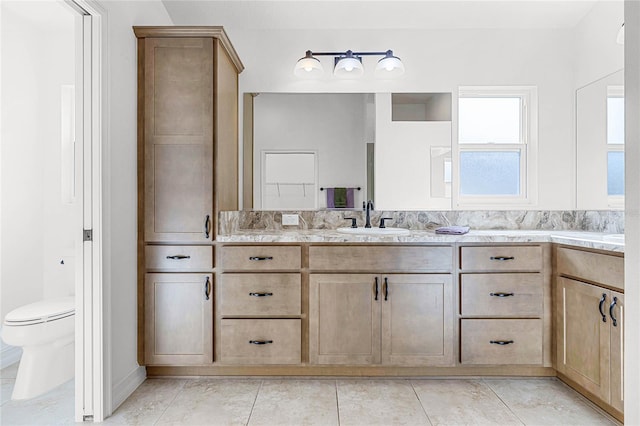 bathroom with tile patterned flooring, vanity, and toilet