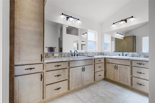 bathroom with tile patterned flooring, vanity, and lofted ceiling