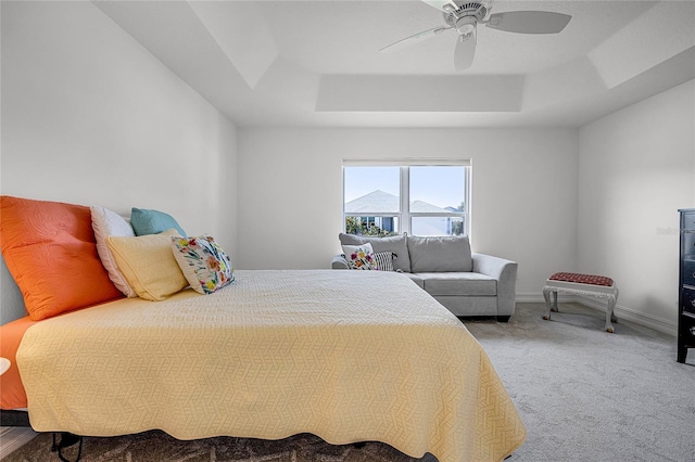 bedroom featuring carpet flooring, ceiling fan, and a raised ceiling