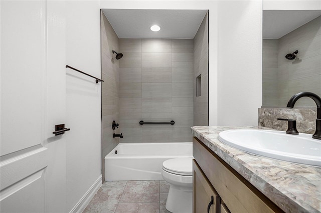 full bathroom featuring tiled shower / bath, tile patterned floors, vanity, and toilet