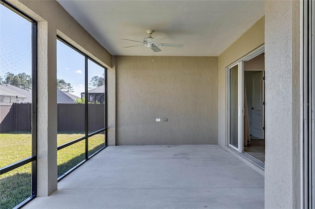 unfurnished sunroom featuring ceiling fan