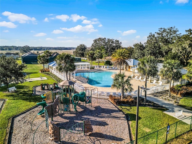 view of pool with a lawn and a playground