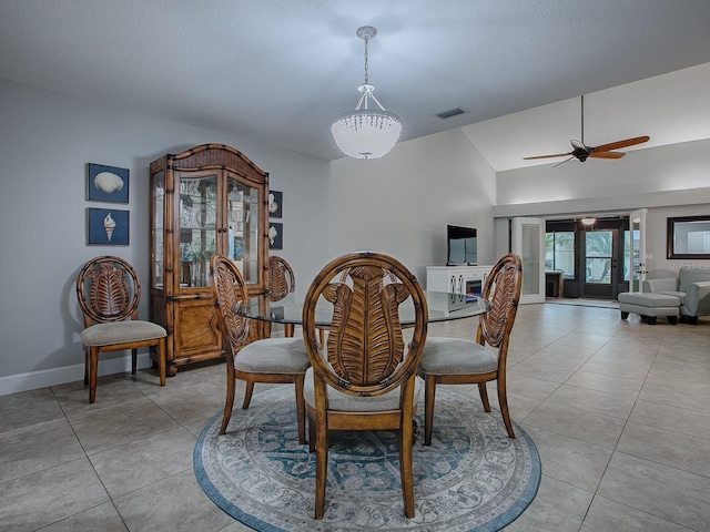 dining space featuring ceiling fan, light tile patterned floors, french doors, and vaulted ceiling