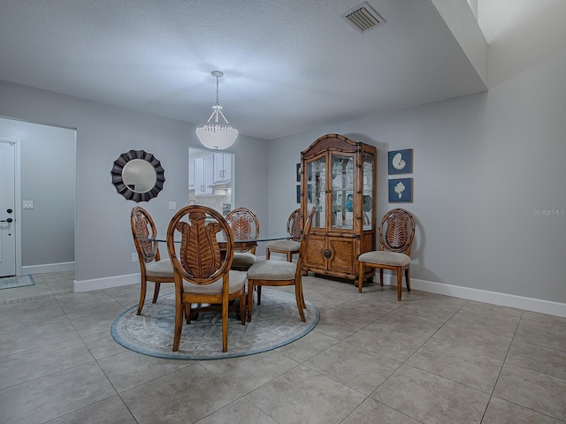 tiled dining area featuring a textured ceiling