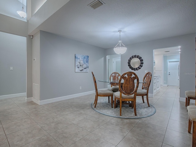 dining room featuring light tile patterned floors and a textured ceiling