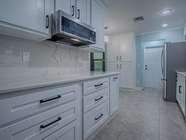 kitchen featuring decorative backsplash, white cabinets, ornamental molding, and appliances with stainless steel finishes