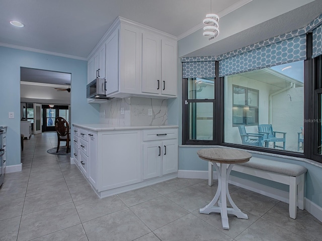 kitchen with backsplash, white cabinetry, ceiling fan, and ornamental molding