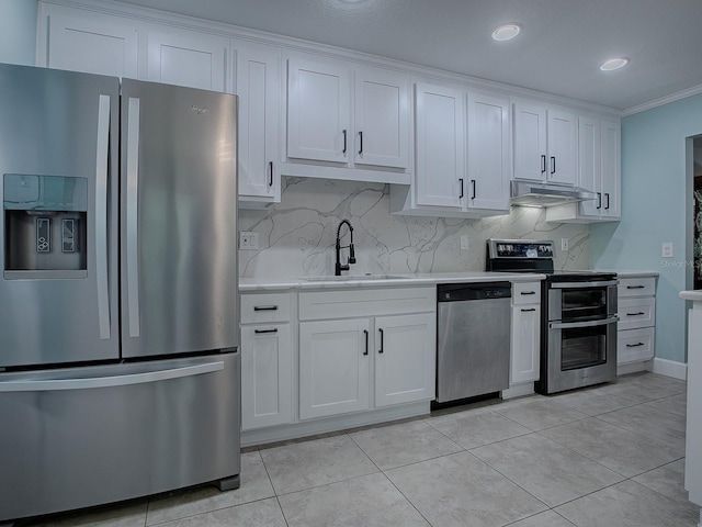 kitchen with crown molding, sink, light tile patterned floors, white cabinetry, and stainless steel appliances