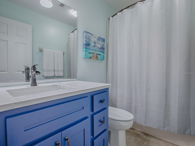 bathroom with tile patterned flooring, vanity, and toilet