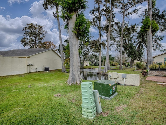 view of yard featuring a water view and cooling unit