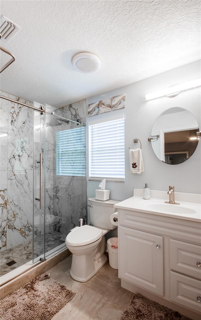 bathroom with vanity, a textured ceiling, toilet, and an enclosed shower