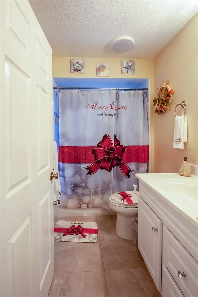 bathroom featuring tile patterned flooring, vanity, a textured ceiling, and toilet