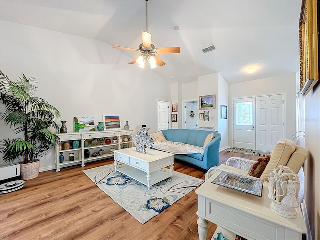 living room featuring ceiling fan, wood-type flooring, and vaulted ceiling