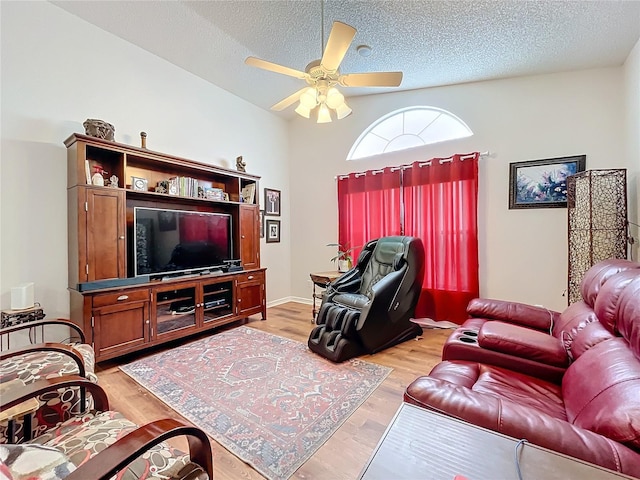 living room with ceiling fan, a textured ceiling, and light hardwood / wood-style flooring