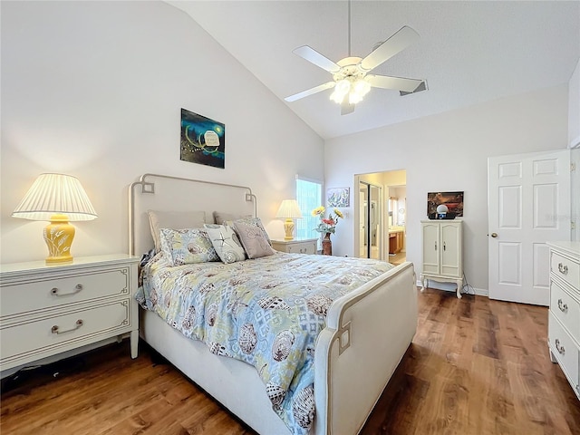 bedroom featuring ceiling fan, dark wood-type flooring, ensuite bathroom, and vaulted ceiling