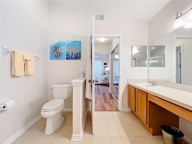 bathroom with toilet, vanity, and tile patterned floors