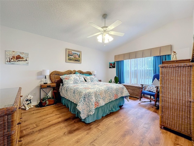 bedroom featuring a textured ceiling, ceiling fan, hardwood / wood-style floors, and vaulted ceiling