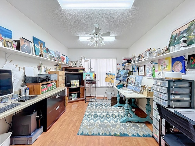 office area with ceiling fan, a textured ceiling, and light wood-type flooring