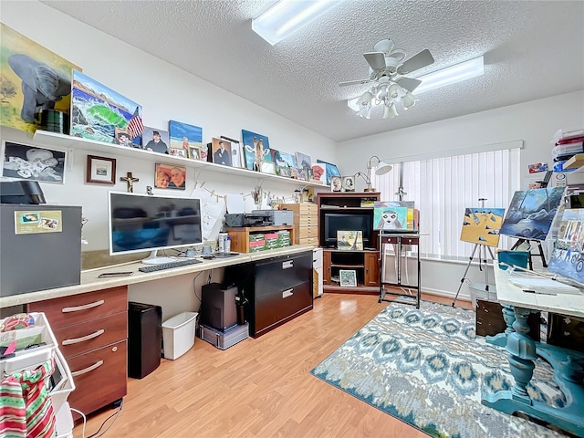 home office with a textured ceiling, light hardwood / wood-style flooring, and ceiling fan