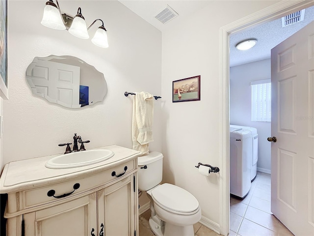 bathroom with tile patterned floors, vanity, a textured ceiling, washing machine and dryer, and toilet