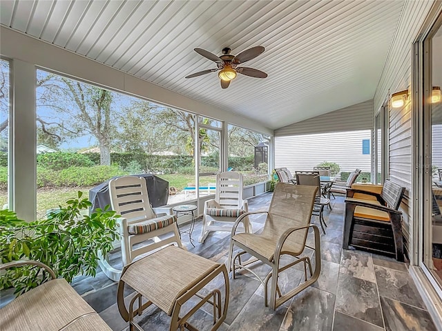 sunroom with ceiling fan and vaulted ceiling