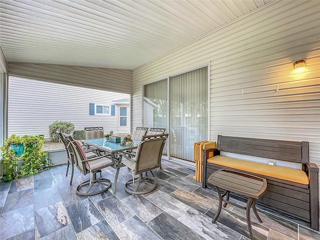 sunroom featuring plenty of natural light and vaulted ceiling