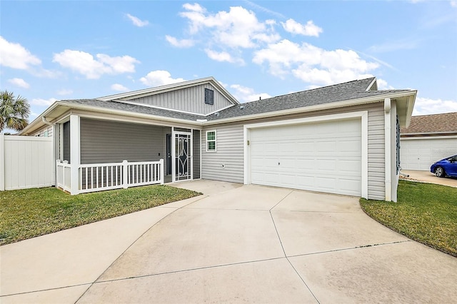 view of front of property featuring covered porch, a front lawn, and a garage