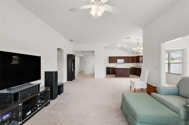 carpeted living room featuring lofted ceiling and ceiling fan with notable chandelier