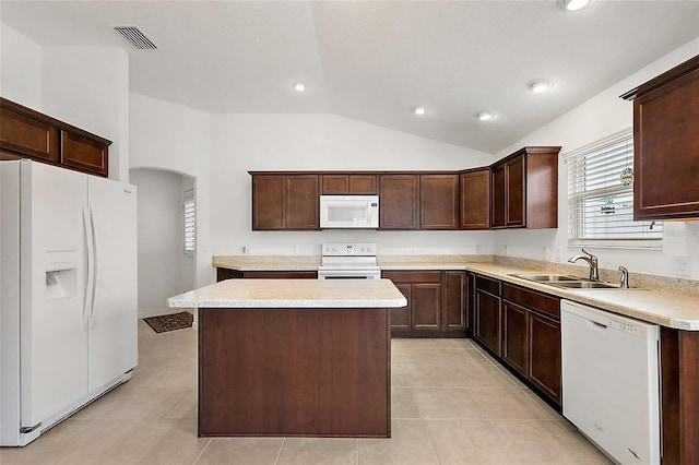 kitchen featuring lofted ceiling, a kitchen island, sink, white appliances, and dark brown cabinetry