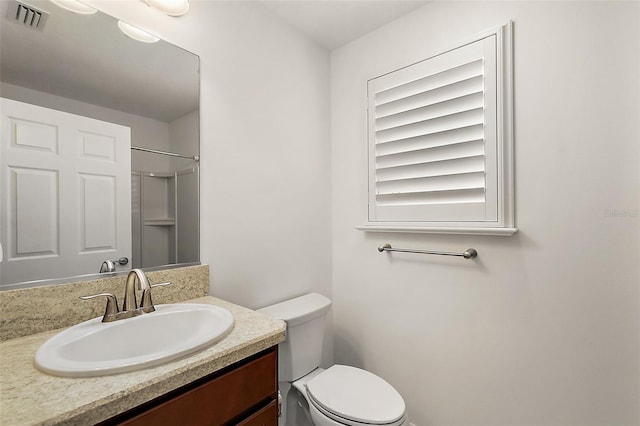 bathroom featuring toilet, walk in shower, and vanity