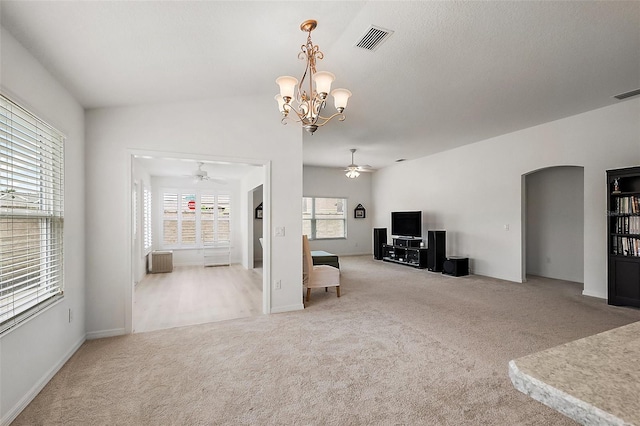 living room featuring ceiling fan with notable chandelier, radiator, and light carpet