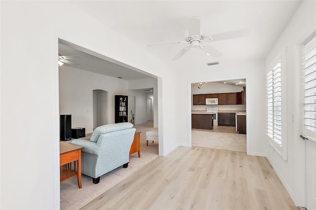 living room with ceiling fan, a healthy amount of sunlight, and light hardwood / wood-style floors