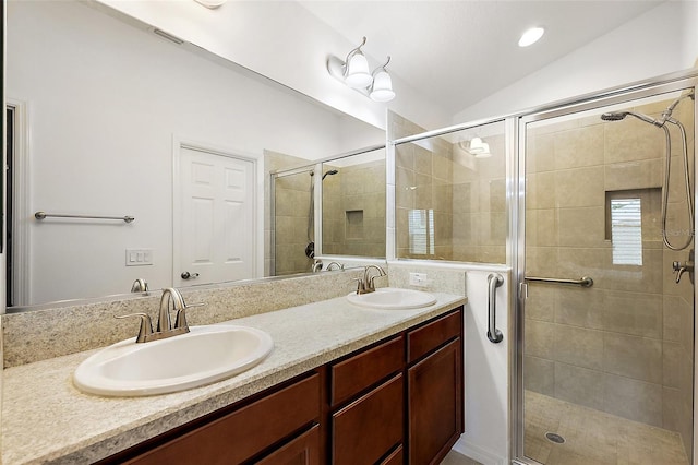 bathroom featuring a shower with shower door, vanity, and vaulted ceiling