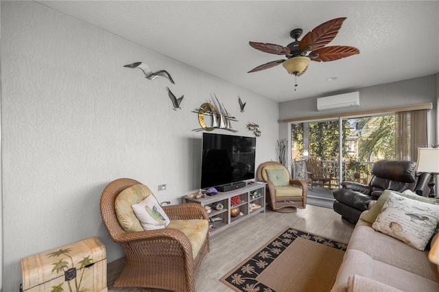 living room with ceiling fan, a wall unit AC, and light hardwood / wood-style flooring