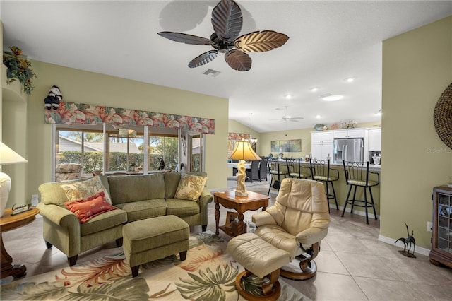 tiled living room featuring ceiling fan and vaulted ceiling