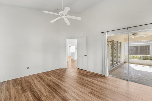 interior space featuring a towering ceiling, light hardwood / wood-style flooring, and ceiling fan