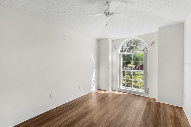 unfurnished room with hardwood / wood-style flooring, ceiling fan, and a textured ceiling