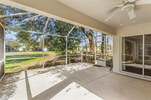 unfurnished sunroom featuring ceiling fan