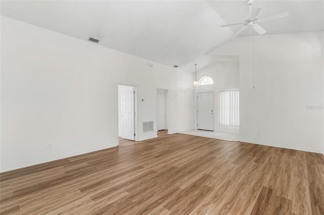 empty room featuring ceiling fan, wood-type flooring, and high vaulted ceiling