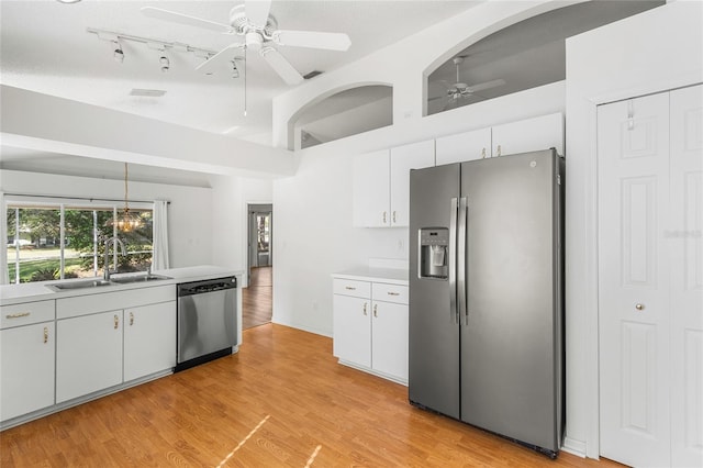 kitchen with appliances with stainless steel finishes, decorative light fixtures, sink, and white cabinets