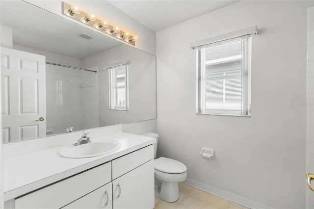 bathroom featuring vanity, toilet, and tiled shower