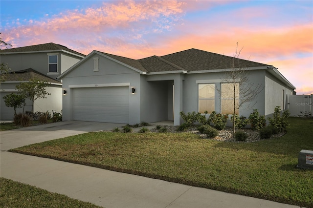 view of front of house with a garage and a lawn