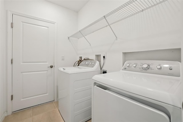 laundry area featuring washer and clothes dryer and light tile patterned floors