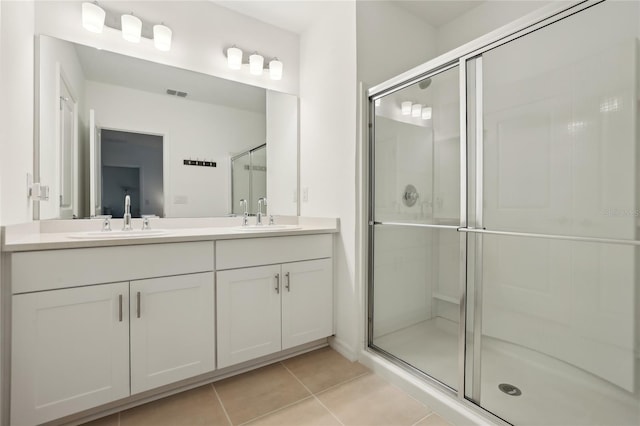 bathroom with tile patterned flooring, vanity, and walk in shower